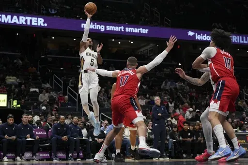 New Orleans Pelicans guard Dejounte Murray (5) goes up to shoot against Washington Wizards center Jonas Valanciunas (17) during the first half of an NBA basketball game Sunday, Jan. 5, 2025, in Washington. (AP Photo/Jess Rapfogel)