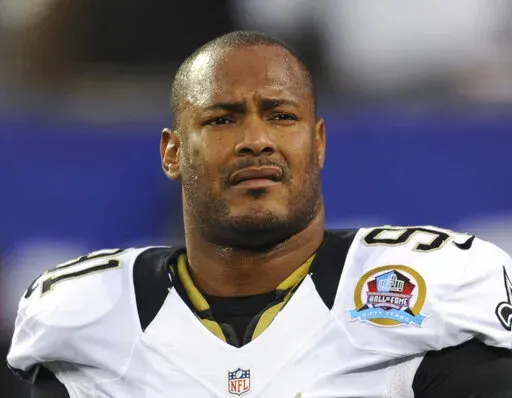 In this Dec. 9, 2012, file photo, New Orleans Saints defensive end Will Smith appears before an NFL football game against the New York Giants in East Rutherford, N.J.  The man convicted of killing Smith and wounding his wife during an argument in New Orleans will go on trial again in August after his conviction was overturned. Orleans Parish Criminal District Judge Camille Buras on Monday, April 4, 2022, set the Aug. 22 date for Cardell Hayes’ retrial after a conference with Hayes’ attorney,