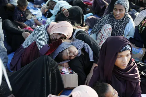 Ethnic Rohingya women rest under a tent after landing on a beach in Kuala Besar, North Sumatra, Indonesia, Sunday, Dec. 31, 2023. Dozens of likely Rohingya refugees, mostly hungry and weak women and children, were found on a beach in Indonesia's North Sumatra province after weeks at sea, officials said on Sunday. (AP Photo/Dedy Zulkifli)