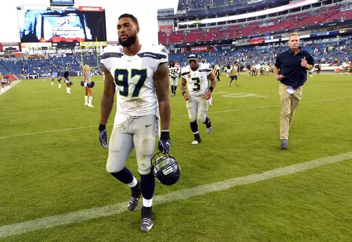 Seattle Seahawks defensive end Marcus Smith (97) and quarterback Russell Wilson (3) leave the field after an NFL football game against the Tennessee Titans Sunday, Sept. 24, 2017, in Nashville, Tenn. The Titans won 33-27. Smith, a 2014 first-round pick by the Philadelphia Eagles, is among many former and active NFL players who have shared their personal stories to break the stigma surrounding mental health and encourage people to seek help they need. (AP Photo/Mark Zaleski, File)