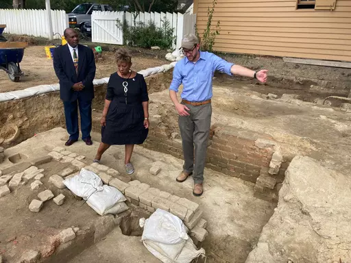 From left, Reginald F. Davis, pastor of First Baptist Church, Connie Matthews Harshaw, a member of First Baptist, and Jack Gary, Colonial Williamsburg's director of archaeology, stand at the brick-and-mortar foundation of one the oldest Black churches in the U.S. on Oct. 6, 2021, in Williamsburg, Va. Experts announced Thursday, April 6, 2023, that three men whose graves were found at the site were members of the church in the early 19th Century. (AP Photo/Ben Finley, File)
