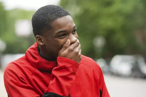 Anthony Perry, 20, reacts after Early Walker, founder of the organization I'm Telling Don't Shoot, surprised him with a free car, Wednesday morning, June 8, 2022, in Chicago. Walker surprised Perry with the car after video of him saving a man from being electrocuted after falling onto the 59th Street red line train tracks went viral earlier in the week. (Pat Nabong/Chicago Sun-Times via AP)