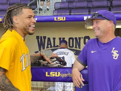 Former LSU safety and current NFL safety for the Kansas City Chiefs smiles as he talks to LSU head coach Jay Johnson before throwing the first pitch during an NCAA baseball game between LSU and Louisiana-Monroe on March 29, 2022, in Baton Rouge, La. Johnson is among the few college baseball coaches from the West Coast who have entered the cauldron that is the Southeastern Conference. (AP Photo/Matthew Hinton, File)
