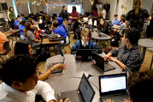 Westwood High School English teacher Jeff Hall, top center, monitors his class, Tuesday, Oct. 18, 2022 in Mesa, Ariz. Like many school districts across the country, Mesa has a teacher shortage due in part due to low morale and declining interest in the profession. Five years ago, Mesa allowed Westwood to pilot a program to make it easier for the district to fill staffing gaps, grant educators greater agency over their work and make teaching a more attractive career. The model, known as team teac
