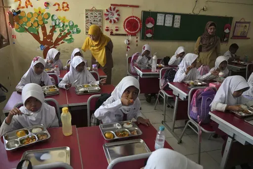 Students have their meals during the kick off of President Prabowo Subianto's ambitious free meal program to feed children and pregnant women nationwide despite critics saying that its required logistics could hurt Indonesia's state finances and economy, at an elementary school in Depok, West Java, Indonesia, Monday, Jan. 6, 2025. (AP Photo/Dita Alangkara)