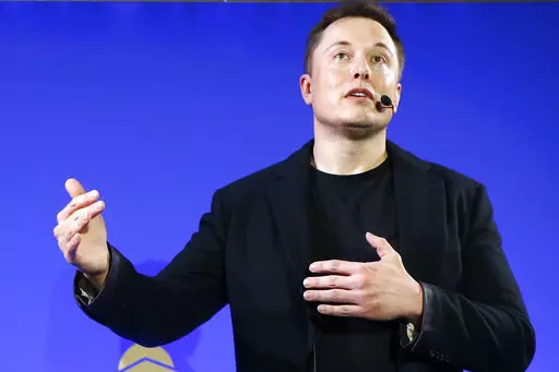 Tesla Motors, Inc. CEO Elon Musk speaks at the Paris Pantheon Sorbonne University as part of the COP21, United Nations Climate Change Conference in Paris on Dec. 2, 2015. An early prototype of Tesla Inc.'s proposed Optimus humanoid robot slowly and awkwardly walked onto a stage, turned, and waved to a cheering crowd at the company's artificial intelligence event Friday, Sept. 30, 2022. (AP Photo/Francois Mori, File)