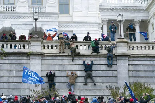 FILE - Violent insurrectionists loyal to then President Donald Trump climb the west wall of the the U.S. Capitol in Washington, Jan. 6, 2021. The House committee investigating the Jan. 6 insurrection at the Capitol has agreed to defer its request for hundreds of pages of records from the Trump administration, bending to the wishes of the Biden White House. (AP Photo/Jose Luis Magana, File)