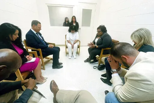 In this April 6, 2022 photo provided by Texas state Rep. Jeff Leach, Texas death row inmate Melissa Lucio, dressed in white, leads a group of seven Texas lawmakers in prayer in a room at the Mountain View Unit in Gatesville, Texas. The lawmakers visited Lucio to update her about their efforts to stop her April 27 execution. The lawmakers say they are troubled by Lucio’s case and believe her execution should be stopped as there are legitimate questions about whether she is guilty. (Texas state 