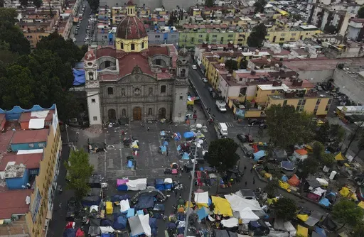 An aerial view of a migrant tent encampment set up on the plaza of the Santa Cruz y La Soledad Catholic parish church, in La Merced neighborhood of Mexico City, Dec. 26, 2023. (AP Photo/Marco Ugarte, File)