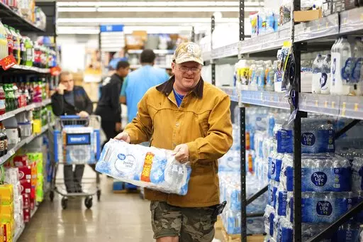 John Beezley, of Bonham, buys cases of water after learning that a boil water notice was issued for the entire city of Houston on Sunday, Nov. 27, 2022, at Walmart on S. Post Oak Road in Houston. Beezley just arrived in town with his wife, who is undergoing treatment starting tomorrow at M.D. Anderson Cancer Center, where they are staying in a camping trailer. They turned on the television after settling in and saw that a boil water notice had been issued. Beezley decided to go out immediately f