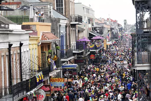 Crowds are seen packing Bourbon Street on Mardi Gras day in New Orleans on Feb. 25, 2020. More than 100 people have joined a lawsuit against New Orleans’ mayor and health director over COVID-19 restrictions that recently were extended to parade and other participants on Mardi Gras and during the season leading up to it. The 2020 festival was recognized as a super spreader that turned New Orleans into an early pandemic hot spot. Last season, parades were canceled and bars were shuttered in the 
