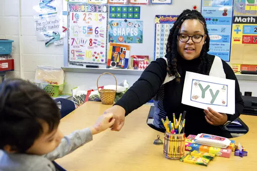 Student teacher Lana Scott, who plans to graduate from Bowie State University in the spring of 2023, teaches a small group of kindergartners at Whitehall Elementary School the alphabet, Tuesday, Jan. 24, 2023, in Bowie, Md. (AP Photo/Julia Nikhinson)
