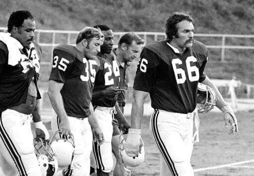 St. Louis Cardinals' Conrad Dobler (66) leads the march off the field at the end of practice at the Cardinals' training camp at St. Charles, Mo., Aug. 5, 1977. Dobler, one of the NFL's top offensive linemen with the St. Louis Cardinals in the 1970s, has died. He was 72. The Cardinals announced Dobler died Monday, Feb. 13, 2023, in Pueblo, Colo. No cause of death was given. (AP Photo/File)