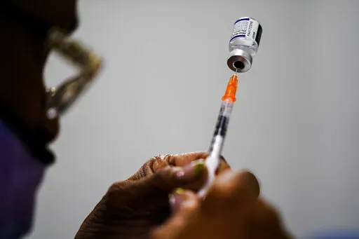 A syringe is prepared with the Pfizer COVID-19 vaccine at a vaccination clinic at the Keystone First Wellness Center in Chester, Pa., Dec. 15, 2021. A federal appeals court is being asked Monday, May 23, 2022, to reconsider its decision allowing the Biden administration to require that federal employees get vaccinated against COVID-19. (AP Photo/Matt Rourke, File)