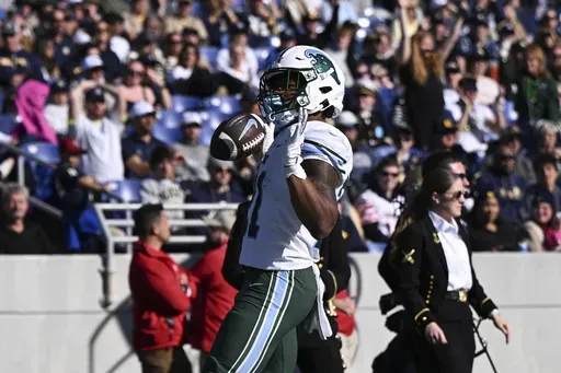 Tulane running back Makhi Hughes celebrates after scoring a touchdown during the first half of an NCAA college football game against Navy, Saturday, Nov. 16, 2024, in Annapolis, Md. (AP Photo/Terrance Williams)
