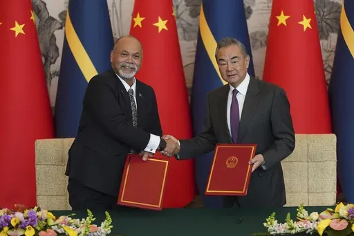 Chinese Foreign Minister Wang Yi, right and Minister of Foreign Affairs and Trade of Nauru Lionel Aingimea shake hands after signing a joint communique on the resumption of diplomatic relations between China and Nauru at Diaoyutai State Guesthouse in Beijing, Wednesday, Jan. 24, 2024. (AP Photo/Andrea Verdelli, Pool)