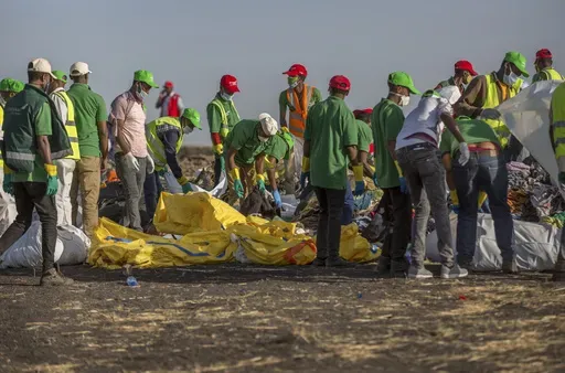 Workers collect debris on March 12, 2019 at the scene where an Ethiopian Airlines Boeing 737 Max 8 crashed shortly after takeoff, killing all 157 on board, near Bishoftu, or Debre Zeit, south of Addis Ababa, in Ethiopia. On Sunday, July 7, 2024, the Justice Department said Boeing has agreed to plead guilty to a criminal fraud charge stemming from two deadly crashes of 737 Max jetliners. (AP Photo/Mulugeta Ayene, File)