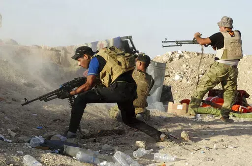 In this Monday, June 15, 2015, Iraqi security forces defend their positions against an Islamic State group attack in Husaybah, 8 kilometers (5 miles) east of Ramadi, Iraq. (AP Photo, File)