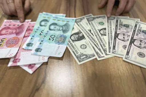 Paek H.O, who defected from the northeastern North Korean town of Musan in 2018, speaks in front of U.S. dollar and Chinese yuan notes during an interview in Seoul, South Korea, on May 3, 2023. North Korea has tolerated the widespread use of more stable foreign currencies like U.S. dollars and Chinese yuan since a bungled revaluation of the won in 2009 triggered runaway inflation and public unrest. Paek said she used the yuan to buy expensive goods and the won for cheap items such as sodas, vege