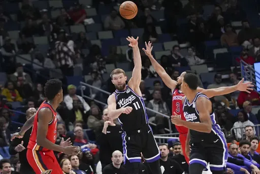 Sacramento Kings forward Domantas Sabonis (11) passes the ball over New Orleans Pelicans center Yves Missi, left, and guard CJ McCollum (3) in the second half of an NBA basketball game in New Orleans, Thursday, Dec. 12, 2024. The Kings won 111-109. (AP Photo/Gerald Herbert)