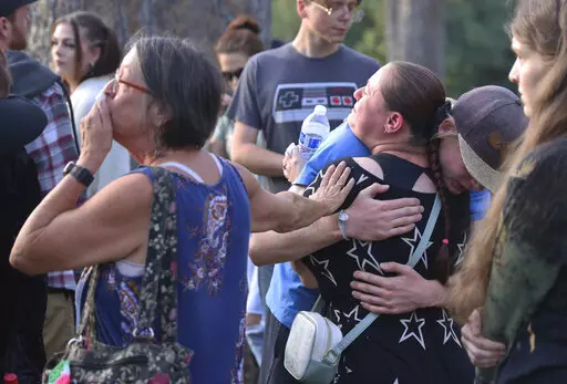 People gather in Drake Park for a vigil in honor of the community members killed in Sunday's shooting at the Forum shopping center in Bend, Ore., on Monday, Aug. 29, 2022.  (Dean Guernsey/The Bulletin via AP)