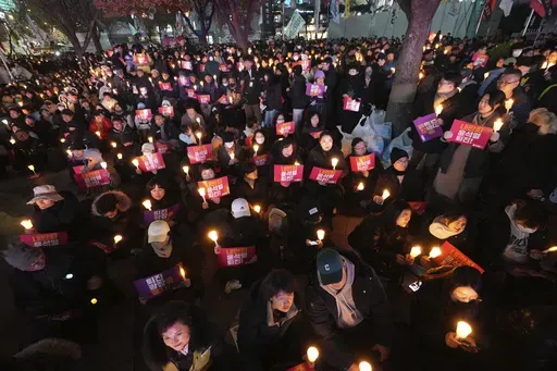 People hold candles during a candlelight vigil against South Korean President Yoon Suk Yeol in Seoul, South Korea, Wednesday, Dec. 4, 2024. (AP Photo/Lee Jin-man)