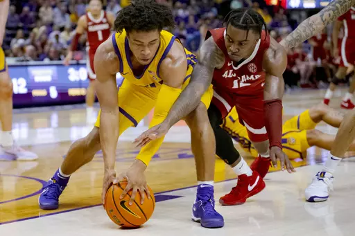 LSU guard Jalen Cook (3) and Alabama guard Latrell Wrightsell Jr. (12) battle for the ball during the first half of an NCAA college basketball game in Baton Rouge, La., Saturday, Feb. 10, 2024. (AP Photo/Matthew Hinton)