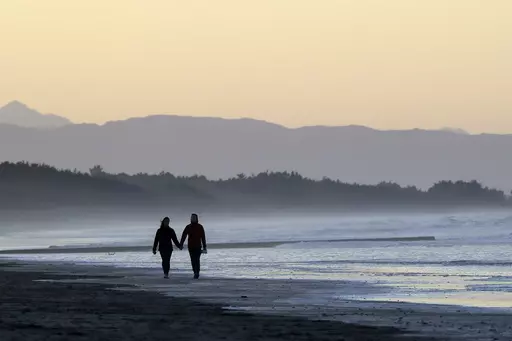 A couple walk along New Brighton Beach at sunset in Christchurch, New Zealand, Tuesday, June 9, 2020. Contrary to popular belief, estate planning isn’t just for older adults or the wealthy, as unexpected circumstances can affect anyone regardless of age or financial status. (AP Photo/Mark Baker, File)