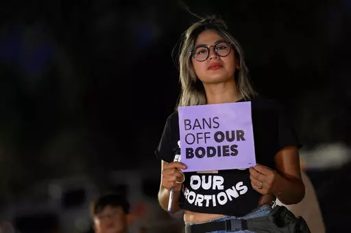 Celina Washburn protests outside the Arizona Capitol to voice her dissent with an abortion ruling, Friday, Sept. 23, 2022, in Phoenix. An Arizona judge ruled the state can enforce a near-total ban on abortions that has been blocked for nearly 50 years. The law was first enacted decades before Arizona became a state in 1912. (AP Photo/Matt York, File)
