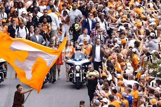 Tennessee head coach Josh Heupel and players greet fans during the traditional Vol Walk before an NCAA college football game against Florida Saturday, Sept. 24, 2022, in Knoxville, Tenn. (AP Photo/Wade Payne)
