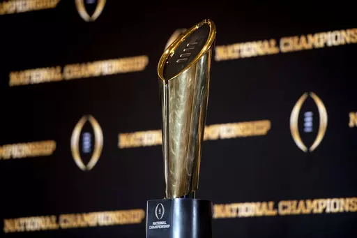 The championship trophy stands on a table during a news conference ahead of the national championship NCAA College Football Playoff game between Georgia and TCU, Sunday, Jan. 8, 2023, in Los Angeles. The first-round games of the inaugural 12-team College Football Playoff will be played on Friday night and Saturday of the third week of December 2024, and the semifinals will be played in early January on weeknights to avoid conflicting with the NFL playoffs, CFP executive director Bill Hancock con