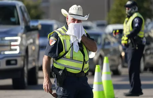 Police officer James Rhodes uses a wet towel to cool off as he directs traffic after a sporting event in Arlington, Texas, Saturday, Aug. 19, 2023. Another record-setting day of high temperatures is forecast in the Dallas/Fort Worth area Saturday, Aug. 26, 2023, before a slight cooling trend moves into the area, according to the National Weather Service as heat warnings stretch from the Gulf Coast to the Southeastern U.S. and upper Mid-South. (AP Photo/LM Otero, File)