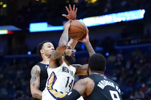 Los Angeles Clippers guard Terance Mann (14) goes to the basket between Los Angeles Clippers forward Marcus Morris Sr., foreground, and guard Amir Coffey in the first half of an NBA basketball game in New Orleans, Thursday, Jan. 13, 2022. (AP Photo/Gerald Herbert)