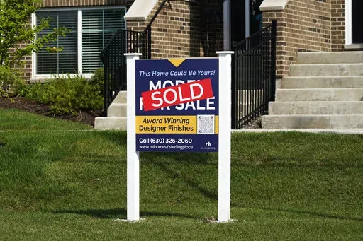 An advertising sign for building land stands in front of a new home construction site in Northbrook, Ill., Wednesday, Sept. 21, 2022. From rising home prices to soaring interest rates, it’s a daunting time to be a home buyer. To achieve homeownership, some single buyers are trying a different approach: co-buying with friends or family members. But co-buying isn’t a short-term hack – it’s a lifestyle shift. Before you team up, experts recommend having vulnerable conversations about your f