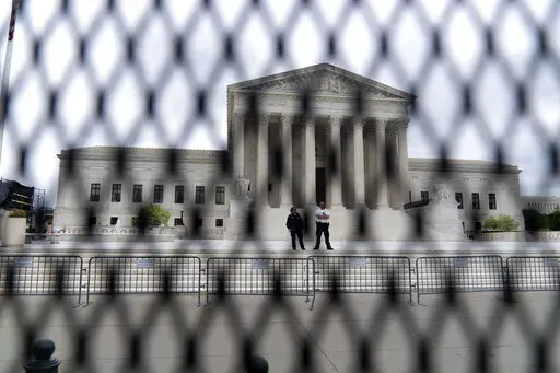 The U.S. Supreme Court is seen behind a fence who stands around the building on Thursday, May 5, 2022 in Washington. One proposal pending in Congress would provide additional security measures for the justices and another would offer more privacy and protection for all federal judges. (AP Photo/Jose Luis Magana, File)