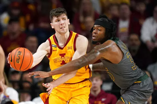 Iowa State guard Caleb Grill, left, passes around Southeastern Louisiana guard Gus Okafor, right, during the second half of an NCAA college basketball game, Sunday, Dec. 19, 2021, in Ames, Iowa. Iowa State won 77-54. (AP Photo/Charlie Neibergall)