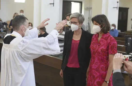 Vicar Wolfgang Rothe, left, blesses the couple Christine Walter, center, and Almut Muenster, right, during a Catholic service with the blessing of same-sex couples in St Benedict's Church in Munich, on May 9, 2021. Pope Francis has formally approved allowing priests to bless same-sex couples, with a new document released Monday Dec. 18, 2023 explaining a radical change in Vatican policy by insisting that people seeking God’s love and mercy shouldn’t be subject to “an exhaustive moral analy