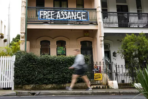 A pedestrian walks past a house with a sign in support of WikiLeaks founder Julian Assange in Sydney, Australia, Monday, June 20, 2022. Australian Prime Minister Anthony Albanese on Monday rejected calls for him to publicly demand the United States drop its prosecution of WikiLeaks founder and Australian citizen Julian Assange.(AP Photo/Mark Baker)