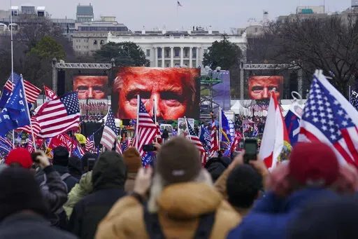 In this Jan. 6, 2021 file photo, Trump supporters participate in a rally in Washington. On Friday, Oct. 21, 2022, The Associated Press reported on stories circulating online incorrectly claiming that former President Donald Trump signed an order to deploy 20,000 National Guard troops before his supporters stormed the U.S. Capitol on Jan. 6, 2021, but was stopped by the House sergeant at arms, at the behest of Speaker Nancy Pelosi.  (AP Photo/John Minchillo, FIle)