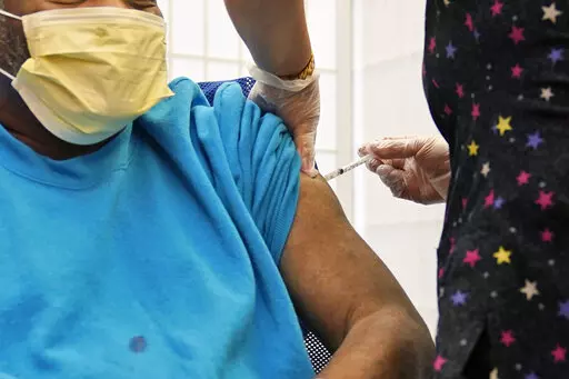 A 62-year-old nursing home resident receives a COVID-19 booster shot in New York on Monday, Sept. 27, 2021. A study released on Wednesday, Jan. 19, 2022 that compares coronavirus protection from prior infection and vaccination in New York and California concludes getting the shots is still the safest way to prevent COVID-19. (AP Photo/Seth Wenig, File)