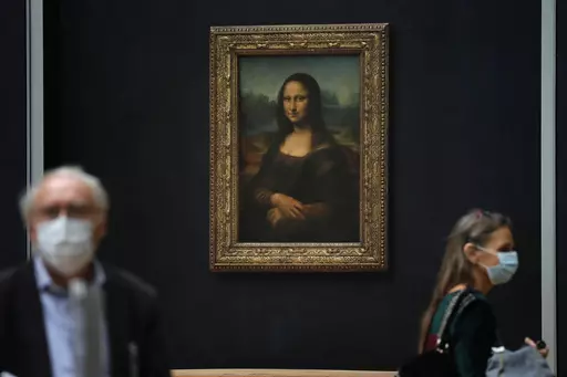 Journalists walk past Leonardo da Vinci's Mona Lisa during a visit of the Louvre museum Tuesday, June 23, 2020. Using X-rays to peer into the chemical structure of a tiny speck of the celebrated work of art, scientists have gained new insight into the techniques that Leonardo da Vinci used to paint his groundbreaking portrait of the woman with the exquisitely enigmatic smile. (AP Photo/Christophe Ena, File)
