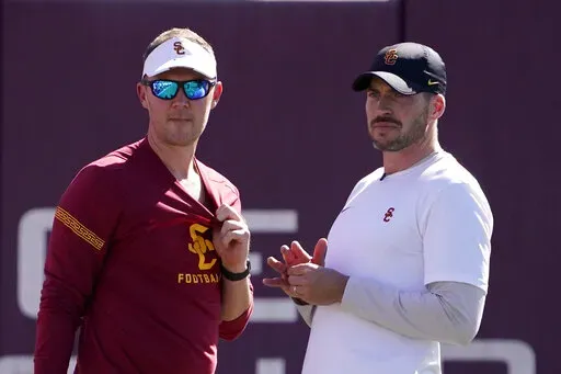 Southern California head coach Lincoln Riley, left, talks with defensive coordinator Alex Grinch during an NCAA college football practice Thursday, March 24, 2022, in Los Angeles. USC has created more turnovers and had more sacks in its first season with defensive coordinator Alex Grinch. (AP Photo/Mark J. Terrill)