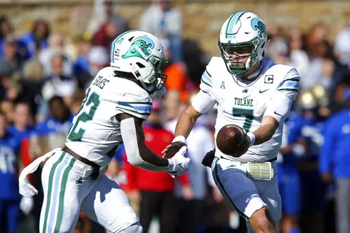 Tulane quarterback Michael Pratt, right, hands the ball to running back Tyjae Spears during the first half of an NCAA college football game against Tulsa in Tulsa, Okla. on Saturday, Nov. 5, 2022. (AP Photo/Dave Crenshaw)
