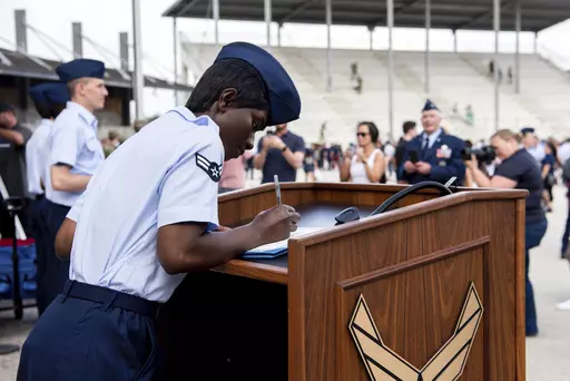 Airman 1st Class D'elbrah Assamoi, from Cote D'Ivoire, signs her U.S. certificate of citizenship after the Basic Military Training Coin Ceremony at Joint Base San Antonio-Lackland, in San Antonio, April 26, 2023. The U.S. military has struggled to overcome recruiting shortfalls and as a way to address that problem, it's stepping up efforts to sign up immigrants, offering a fast track to American citizenship to those who join the armed services. The Army and the Air Force have bolstered their mar