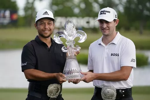 Xander Schauffele, left, and Patrick Cantlay, right, hold up the trophy after winning the PGA Zurich Classic golf tournament at TPC Louisiana in Avondale, La., Sunday, April 24, 2022. The Zurich Classic's unusual two-player team format has attracted a field featuring some of the PGA's most accomplished players -- even without the big purse of an elevated event. Defending champions Cantlay and Schauffele will be up against teams featuring former major winners, including Matt Fitzpatrick with his 