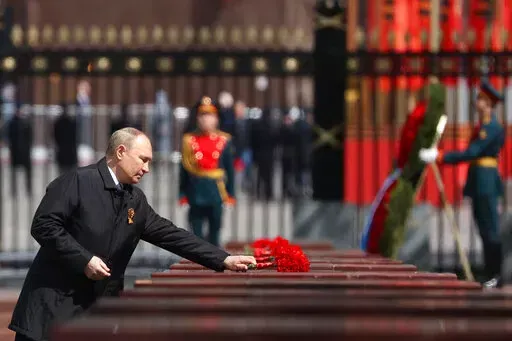 Russian President Vladimir Putin attends a wreath-laying ceremony at the Tomb of the Unknown Soldier after the military parade marking the 77th anniversary of the end of World War II in Moscow, Russia, Monday, May 9, 2022. (Anton Novoderezhkin, Sputnik, Kremlin Pool Photo via AP)