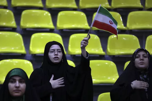 Iranian women listen to their country's national anthem as one of them waves the national flag during an election campaign rally ahead of the March 1, parliamentary and Assembly of Experts elections, in Tehran, Iran, Tuesday, Feb. 27, 2024. Iran is holding parliamentary elections this Friday, yet the real question may not be who gets elected but how many people actually turn out to vote. Separately, Iranians will also vote on Friday for members of the country's 88-seat Assembly of Experts, an ei
