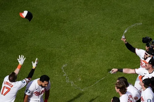Baltimore Orioles designated hitter Anthony Santander, second from left, is greeted by teammates after hitting a walk-off home run during the ninth inning of a baseball game against the San Francisco Giants, Thursday, Sept. 19, 2024, in Baltimore. (AP Photo/Stephanie Scarbrough)