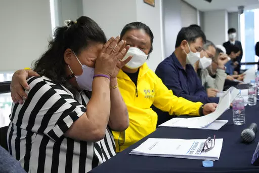 Park Sun-yi, left, a victim of Brothers Home, weeps during a press conference at the Truth and Reconciliation Commission office in Seoul, South Korea, Wednesday, Aug. 24, 2022. The commission has found the country's past military governments responsible for atrocities committed at Brothers Home, a state-funded vagrants' facility where thousands were enslaved and abused from the 1960s to 1980s. (AP Photo/Ahn Young-joon)