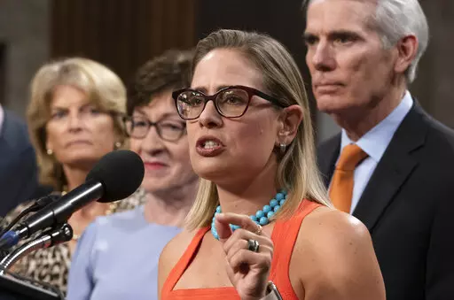 Sen. Kyrsten Sinema, D-Ariz., center, gestures during a news conference at the Capitol in Washington, July 28, 2021, while working on a bipartisan infrastructure bill with, from left, Sen. Lisa Murkowski, R-Alaska, Sen. Susan Collins, R-Maine, and Sen. Rob Portman, R-Ohio. Though elected as a Democrat, Sinema announced Friday, Dec. 9, that she has registered as an Independent, but she does not plan to caucus with Republicans, ensuring Democrats will retain their narrow majority in the Senate. (A